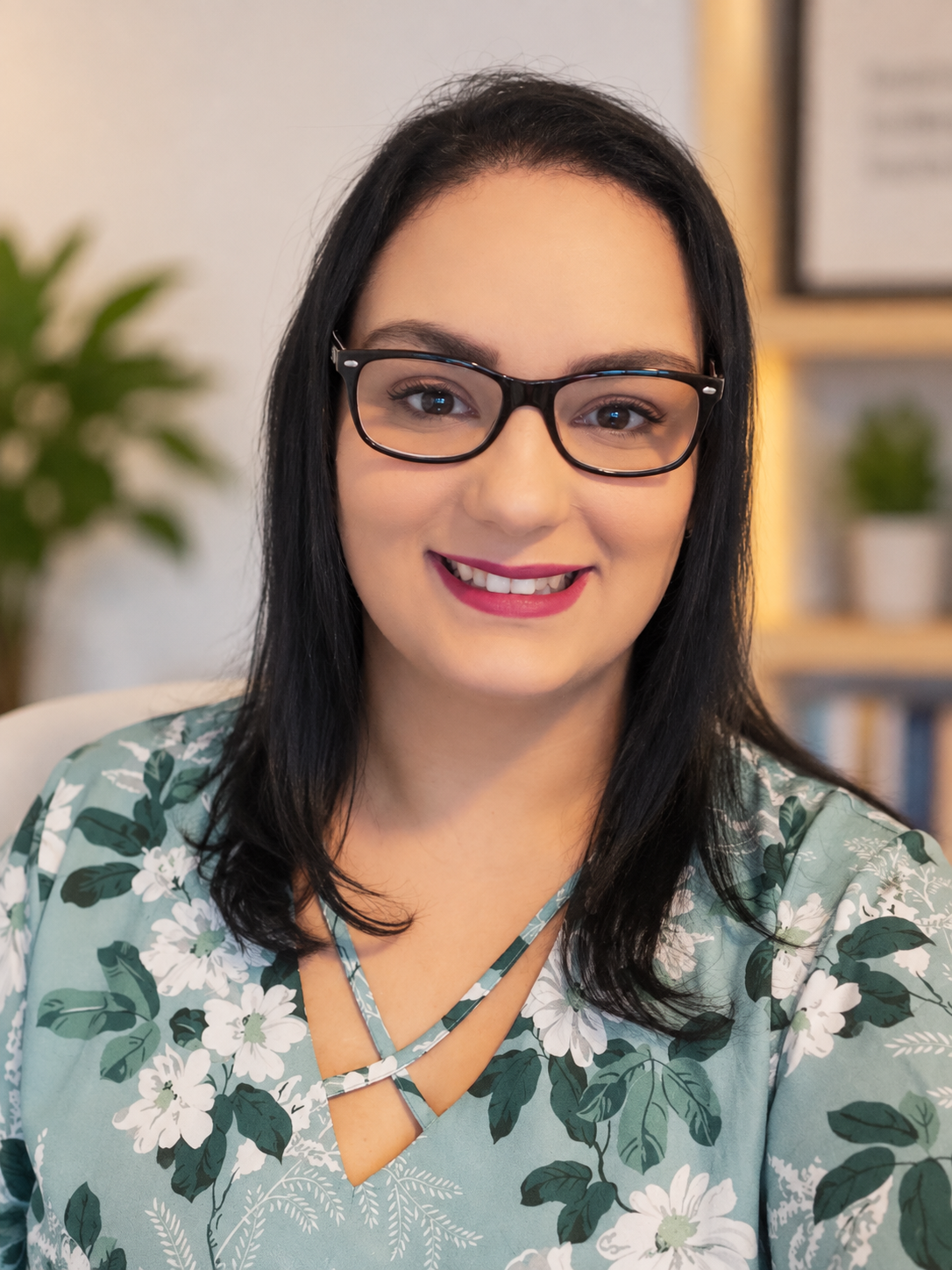 Retrato de Carolina de Assis Leal, psicóloga, sorrindo em seu consultório
